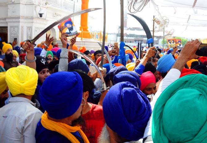 Sikh radicals raising slogans in praise of Khalistan and brandishing swords